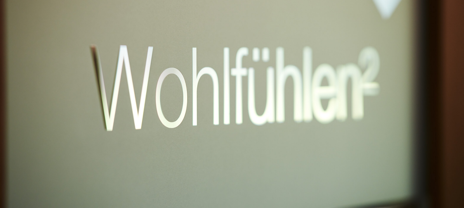 Glastür mit der Aufschrift Wohlfühlen von einem Behandlungsraum im Wellnesshotel in Oberstdorf