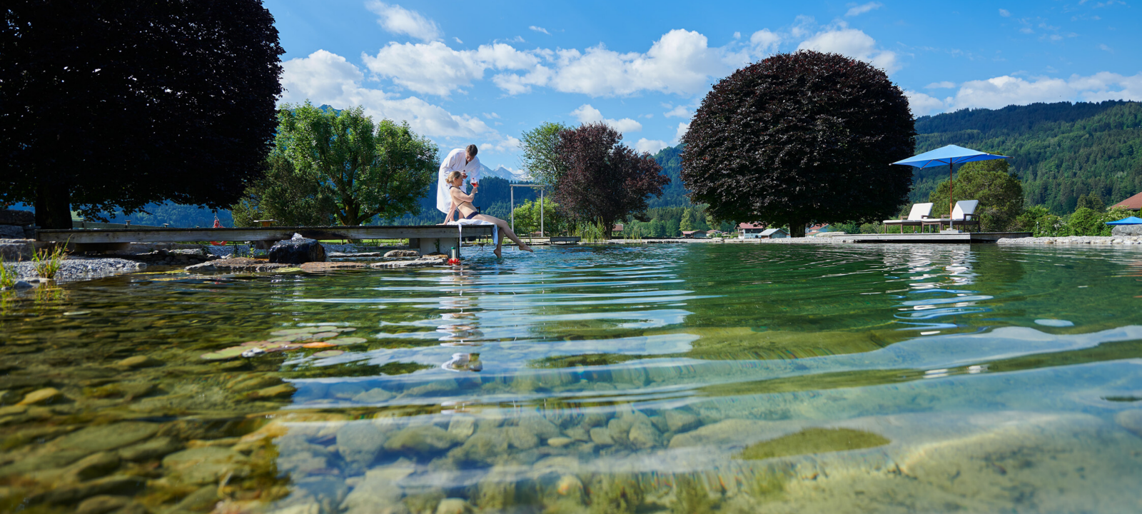 Zwei Personen am Natursee PanoramaQUELL im Sommer in Oberstdorf im Allgäu