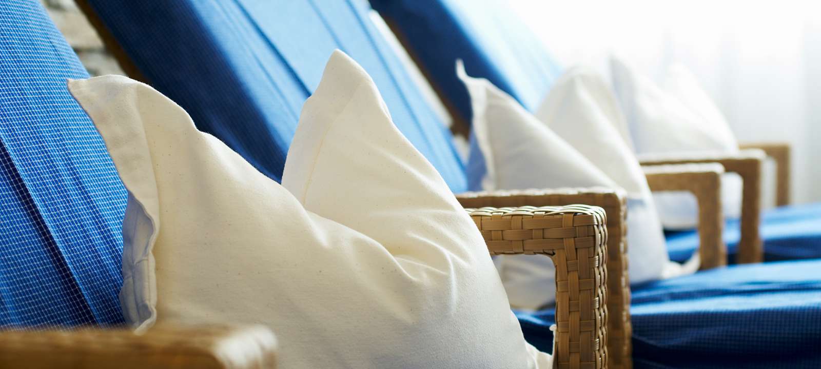 Zwei Badeschlappen und ein paar Füße liegen auf einem Holzsteg am Natursee