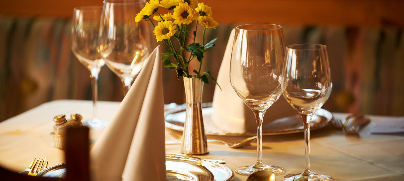 Frau vom Service deckt einen Tisch zum Frühstück mit Geschirr ein auf der Terrasse im Hotel in Oberstdorf