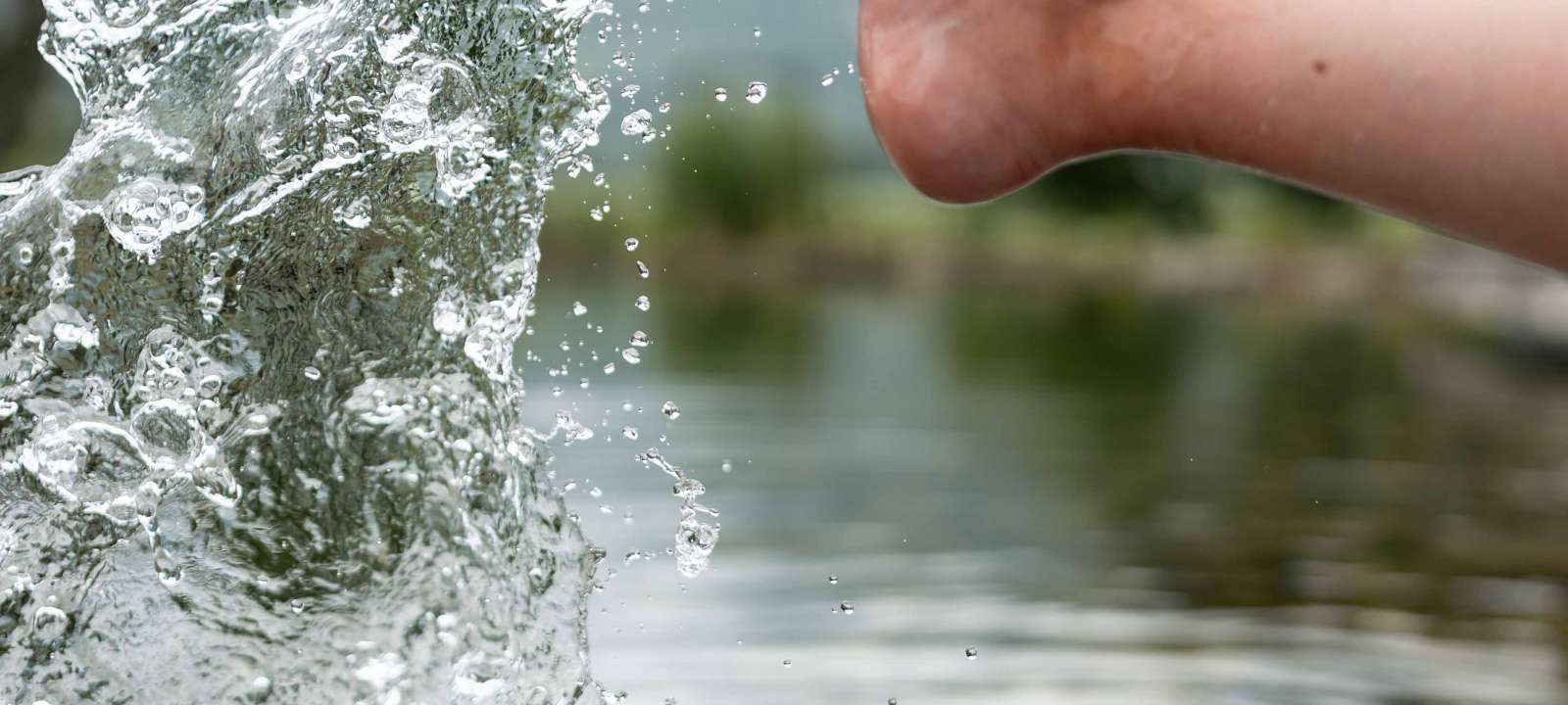 Frau sitzt im Kneippbereich und hält ihre Füße in das Kneippbecken