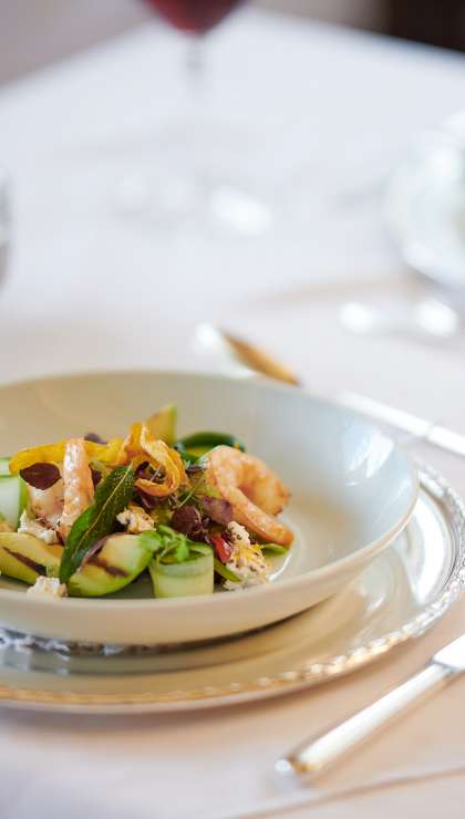 Gedeckter Tisch mit maritimem Essen und einem Glas Rotwein