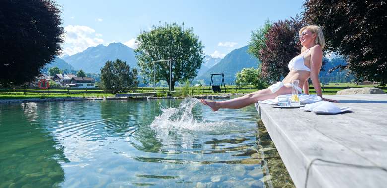 Frau entspannt am Naturteich PanoramaQUELL im Wellnesshotel l in Oberstdorf